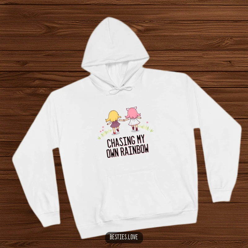Funny and cozy hoodie showing best friends holding hands and skipping along a beautiful, bright rainbow path, radiating happiness.
